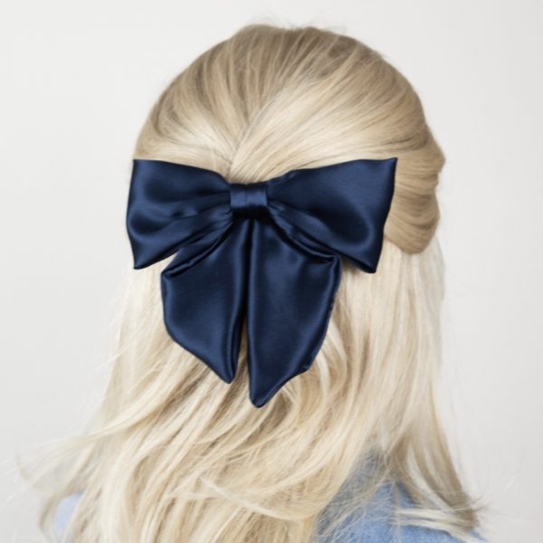 Blonde Frau mit dunkel blauer Haarschleife
