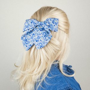 Blonde Frau mit blau-weißer Muster-Haarschleife
