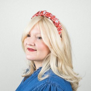 Blonde Frau mit rotem Muster-Haarreif