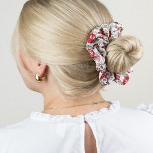 Frau mit blondem Dutt und Blumen-Scrunchie