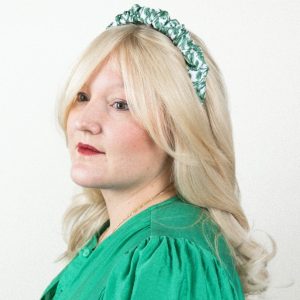 Blonde Frau mit Grün-weiß gemustertem Haarreif